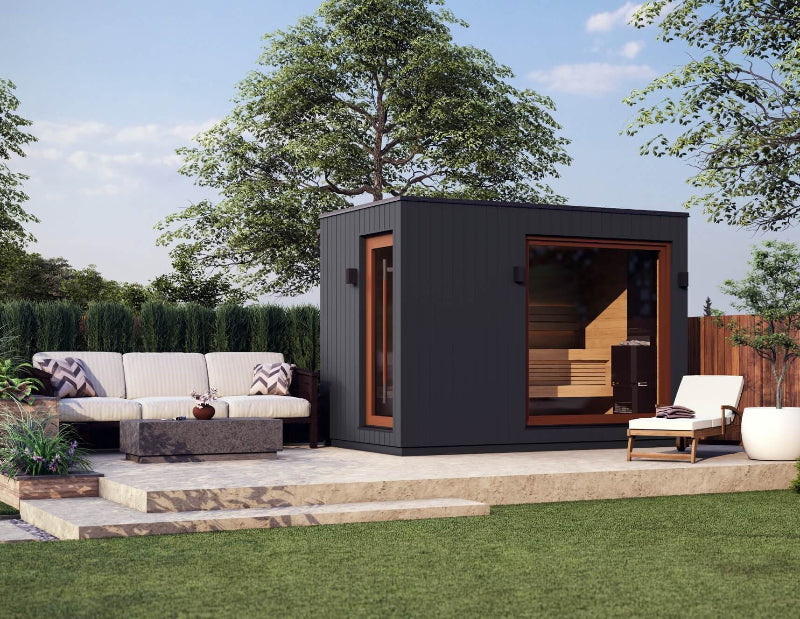Saunum AirCube Double sauna set up in a modern backyard, adjacent to patio seating and landscaping, with large windows revealing the warm wood interior.