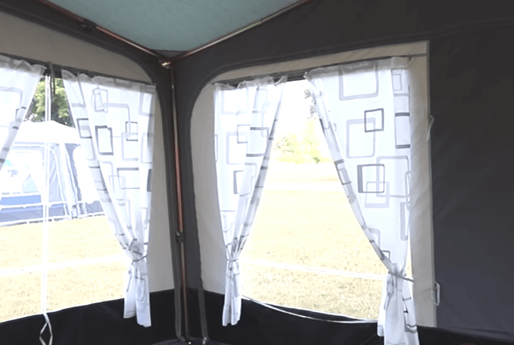 Camptech Duchess 340 porch awning interior view with patterned curtains and window panels, providing bright and spacious caravan extension