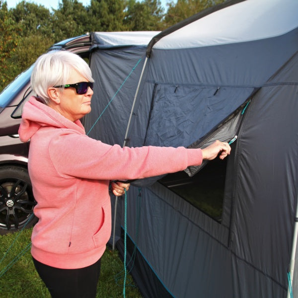 Cayman Cuda FG Driveaway Awning shown with a woman zipping the panel