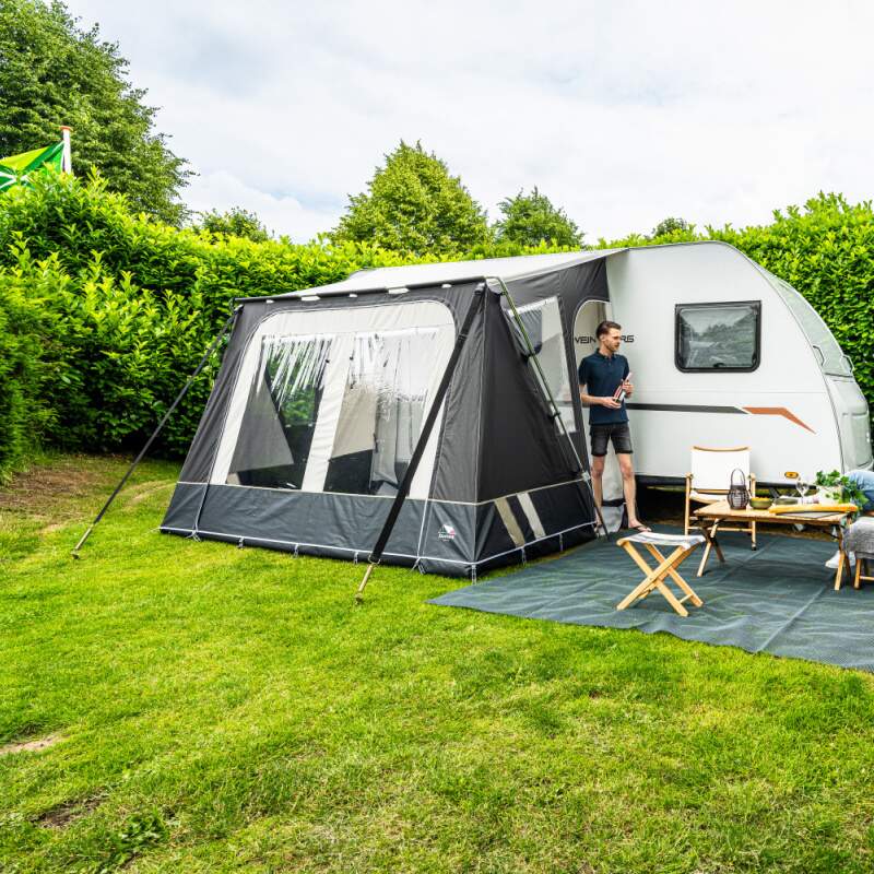 A Dorema Mistral Awning in grey in a field with a man stood in the doorway