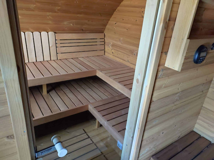 Inside view of the sauna benches and heater area, taken from the doorway , and on a natural wood-toned background.