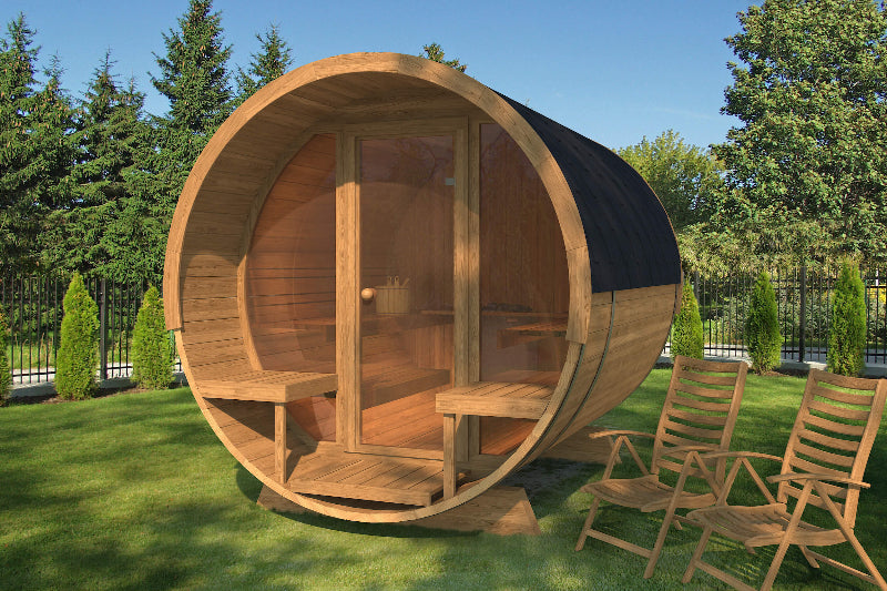 Daytime of InMedias Barrel Sauna 280 Deluxe with fully transparent front and wooden chairs nearby, on a grass background.