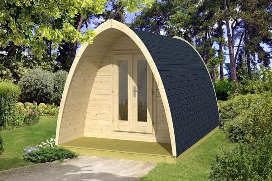 InMedias Camping Pod 400 wooden structure in a lush garden setting, with green grass and trees in the background.