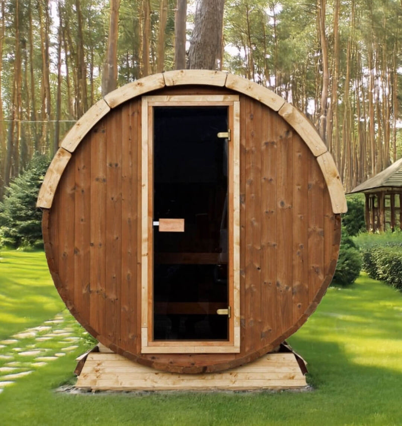 InMedias Terrace Sauna with dark wood exterior placed on green grass with pine trees in the background during daylight.