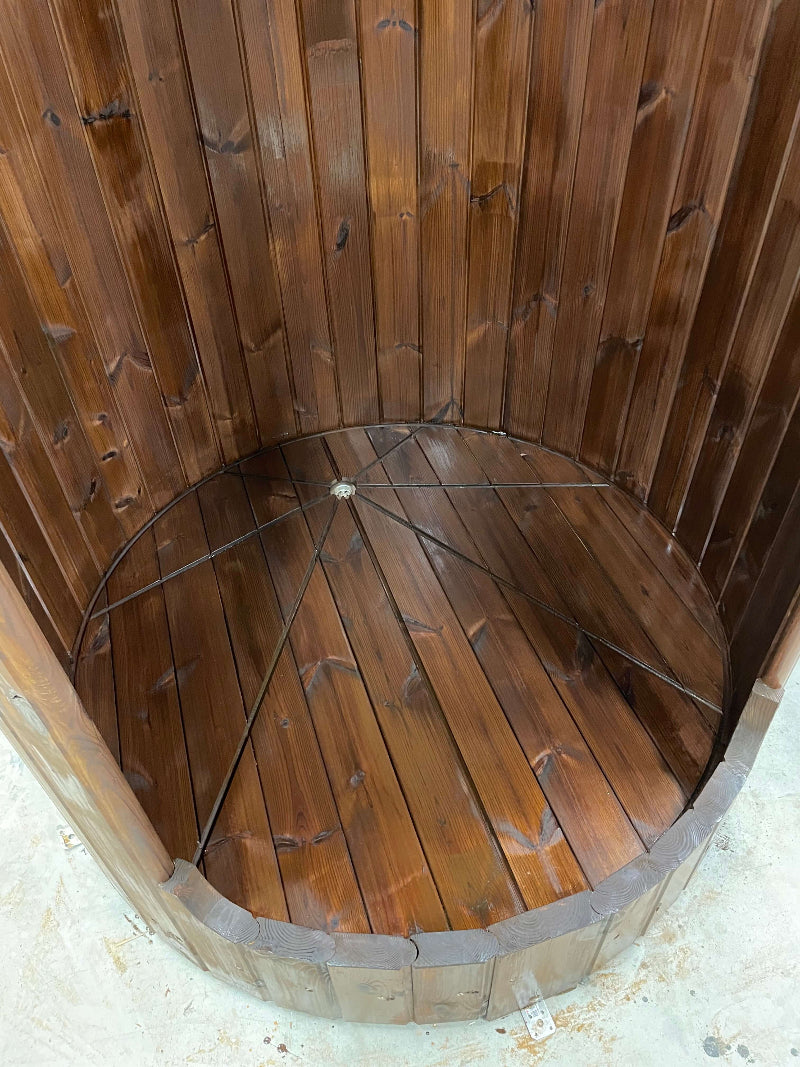 Close-up of classic wood floor with visible drainage in the InMedias Shower Barrel – showing natural brown wooden planks, on a concrete floor.