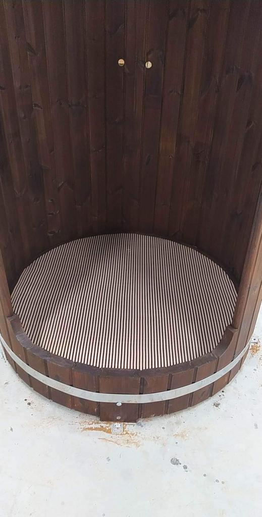 Interior base view of InMedias Shower Barrel – showing a ribbed, light-toned wooden floor with curved walls.