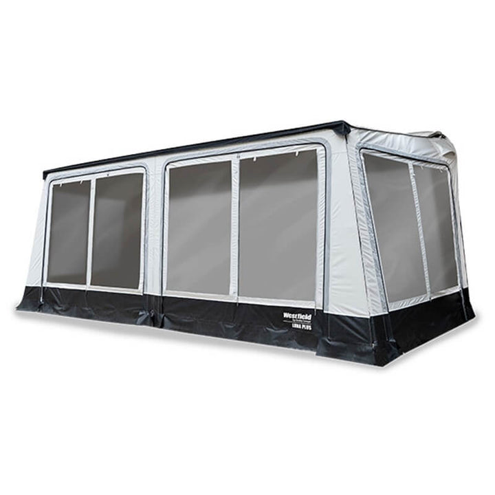 White caravan with full roll-out awning extended,  on a white background.