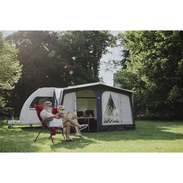 A couple sitting in front of a Vango Riviera Air 390
