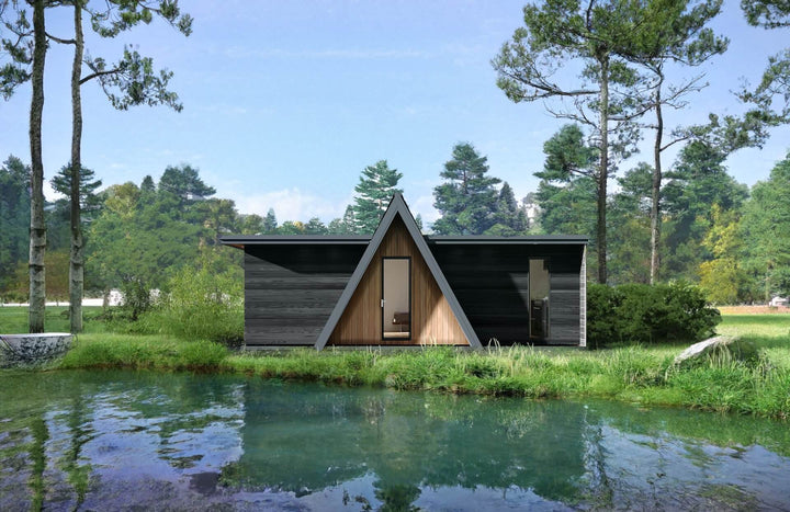 Front-facing view of an A-frame glamping unit reflected in a pond, surrounded by pine trees and forest grass.