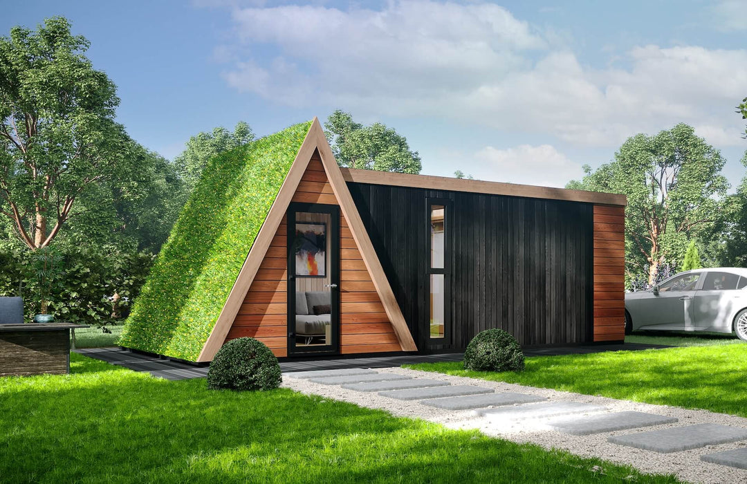 Angled view of the glamping unit featuring a living green roof, wooden A-frame entrance, and a sleek black timber side extension.
