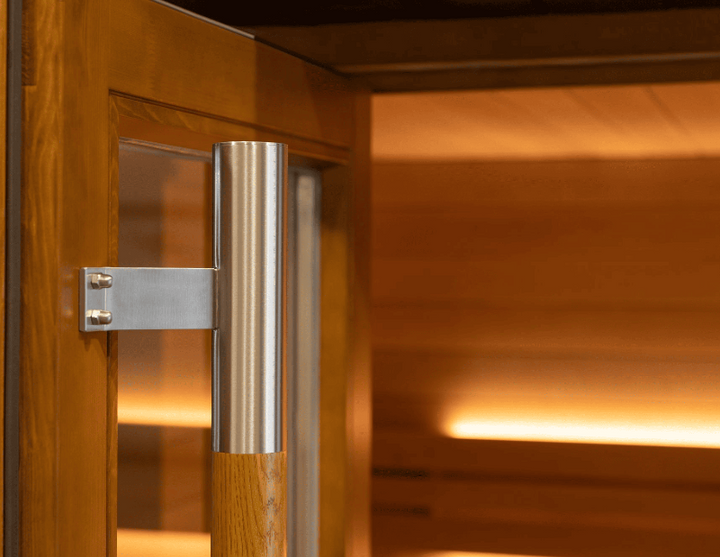 Close-up of the Saunum AirCube One sauna door handle made of brushed metal and wood, highlighting craftsmanship and build quality.