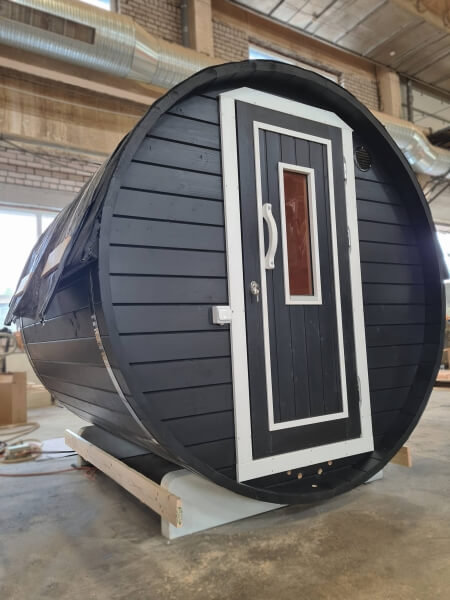Viking Industrier 1.9 x 1.63m Barrel Sauna placed indoors with black and white color scheme.