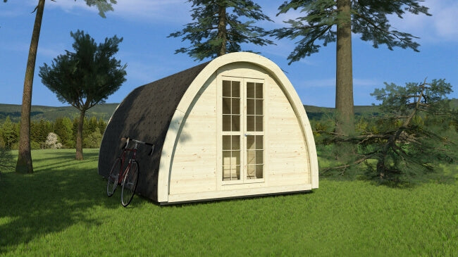 Viking Industrier 2.4 x 4.8m Camping Pod in a forest setting with light wood front and black roof shingles on a grassy background.