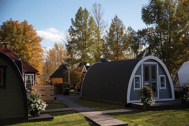 Viking Industrier 3.2 x 5.9m Camping Pod outdoor view in a glamping resort setting surrounded by autumn trees on a grass background.