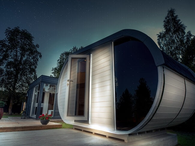 Viking Industrier Delight Outdoor Sauna 2.4 x 4.3m at night with starry sky and exterior lighting on a dark outdoor background.