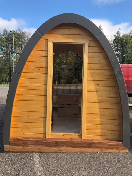 Front view of an unfinished Viking Industrier Sauna Pod 2.4 x 2.3m showing open doorway, on a paved outdoor setting.