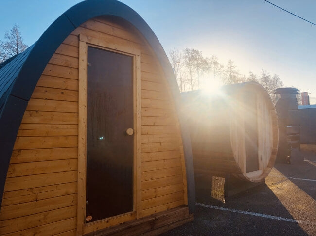 Viking Industrier Sauna Pod 2.4 x 2.3m made of natural wood, captured at sunrise in an outdoor lot.