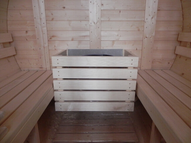 Empty interior of Viking Industrier Barrel Sauna 2.2 x 4m with unfinished heater housing and light wood walls.