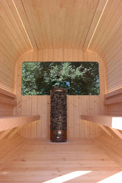 Interior of Viking Industrier Luna Outdoor Sauna 2.3 x 2.4m with wooden benches and a central heater, viewed from the back toward a large window. On a natural background.