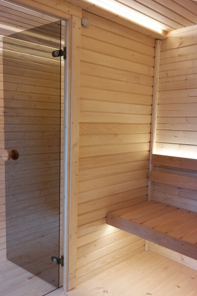 Interior shot of the sauna bench and wall in Viking Industrier Luna Outdoor Sauna 3.3 x 2.4m with ambient lighting.