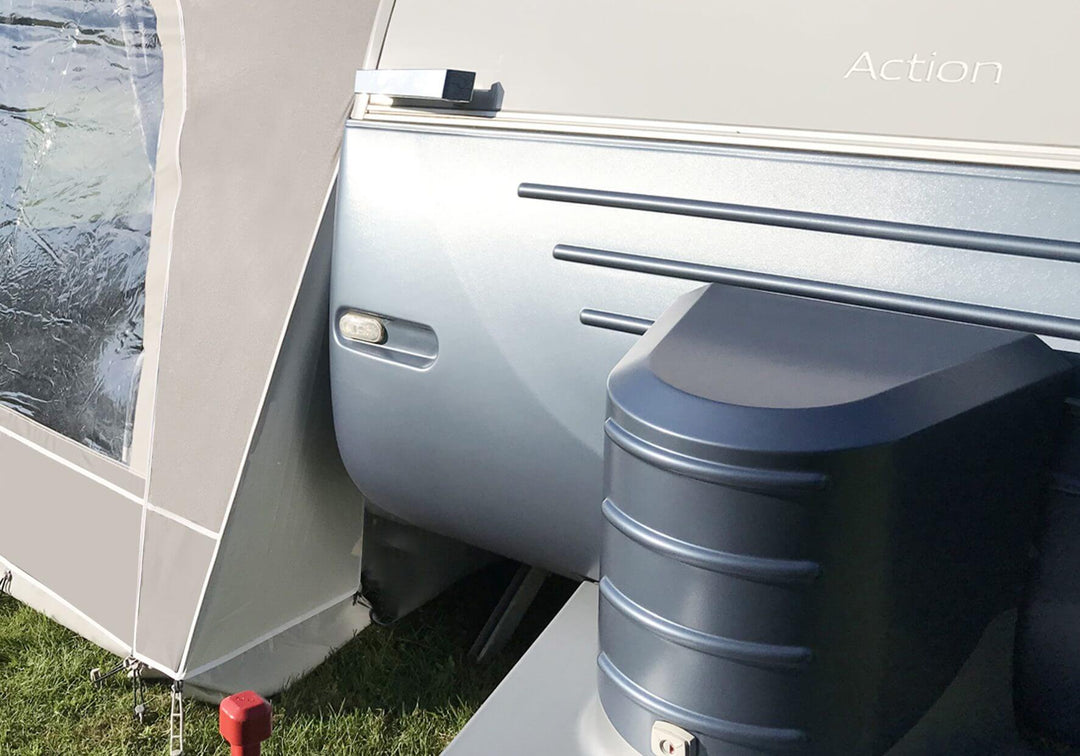 Close-up of the hitch area of the Adria Action 391 caravan, with the Walker awning skirt partially visible.