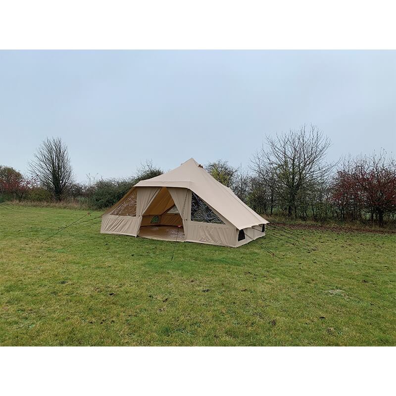 Angled view of the Quest Leisure Signature Touareg bell tent on a grassy field with autumn trees in the distance.