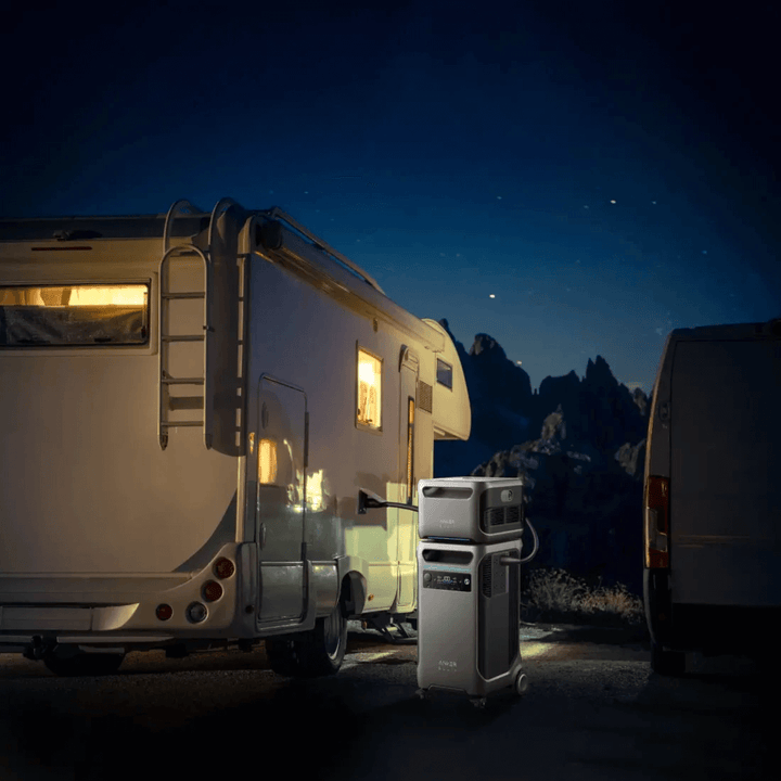 Anker portable power station connected to RV under starry night sky, in an outdoor campsite setting.