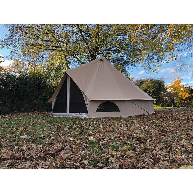 Quest Leisure Signature 4M Classic Bell Tent set up on a bed of autumn leaves with a clear blue sky and trees.