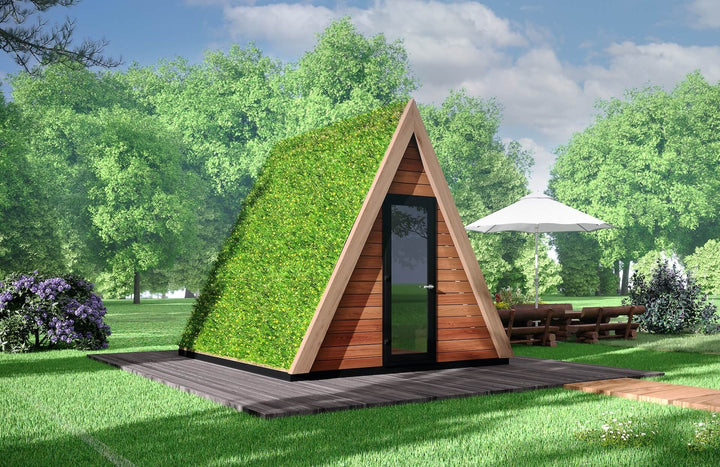 A-frame pod with lush green living roof and wooden slats on a dark wood platform, outdoor furniture and umbrella nearby.