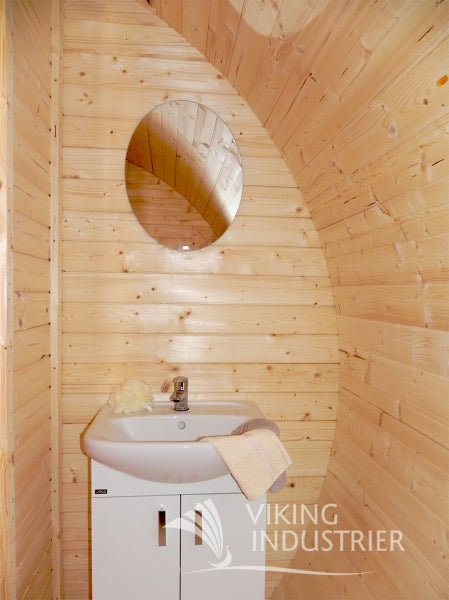 Interior view of the Viking Industrier Ice-Viking Sleeping Barrel 3 x 4.8m with a round mirror and a white sink.
