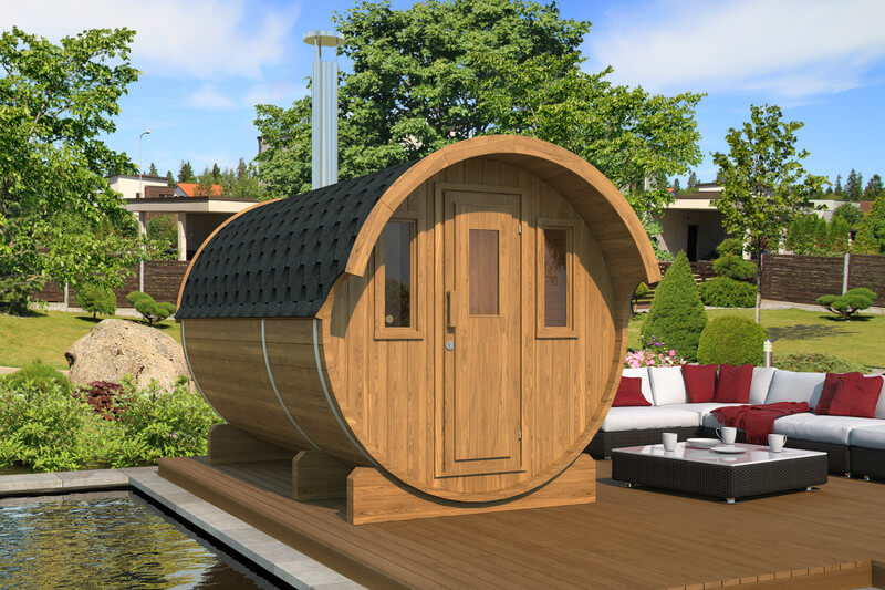 InMedias Barrel Sauna 330 in dark wood finish placed on a deck beside an outdoor lounge area — on a garden background.