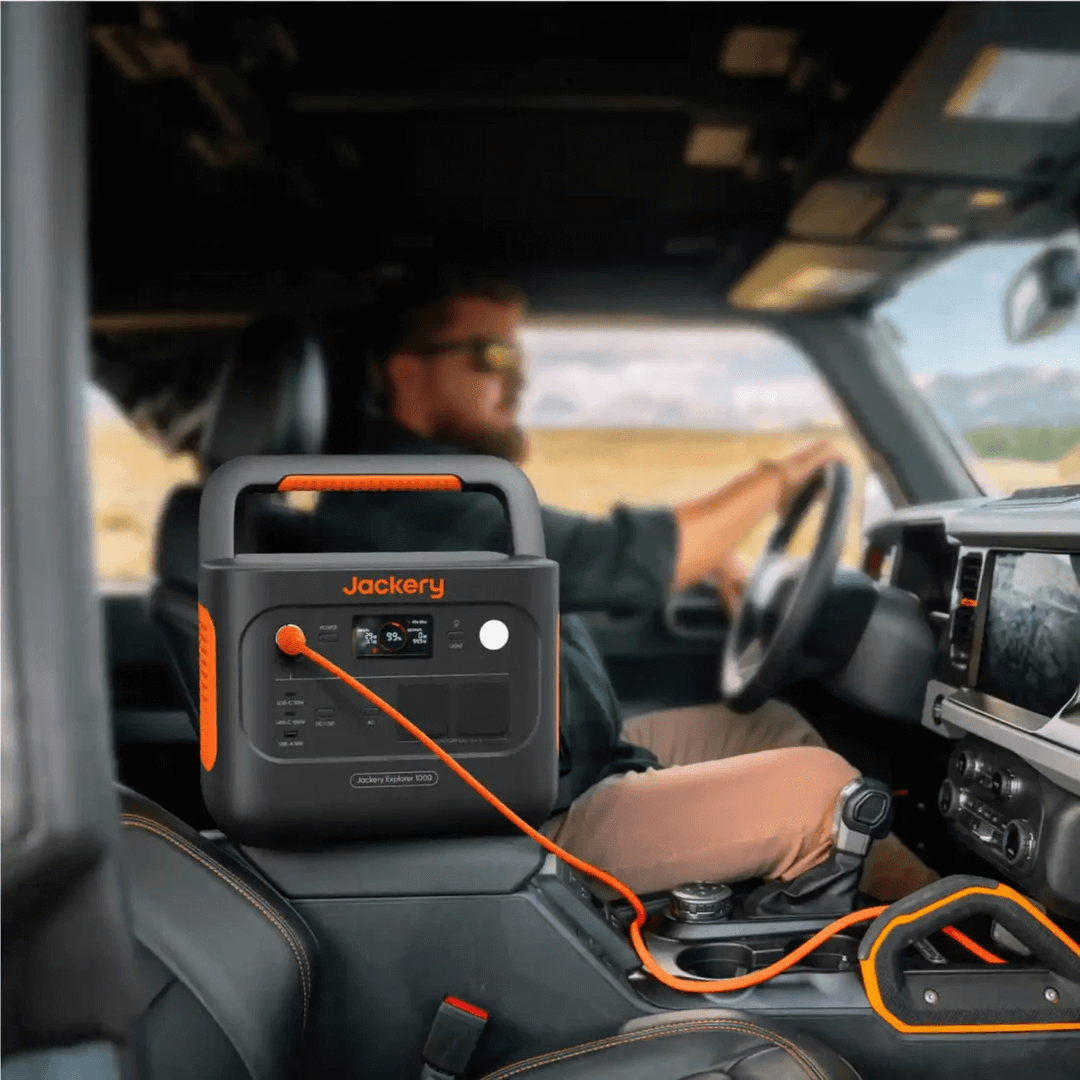 Jackery Explorer 1000 V2 charging inside a vehicle, with driver in the background.