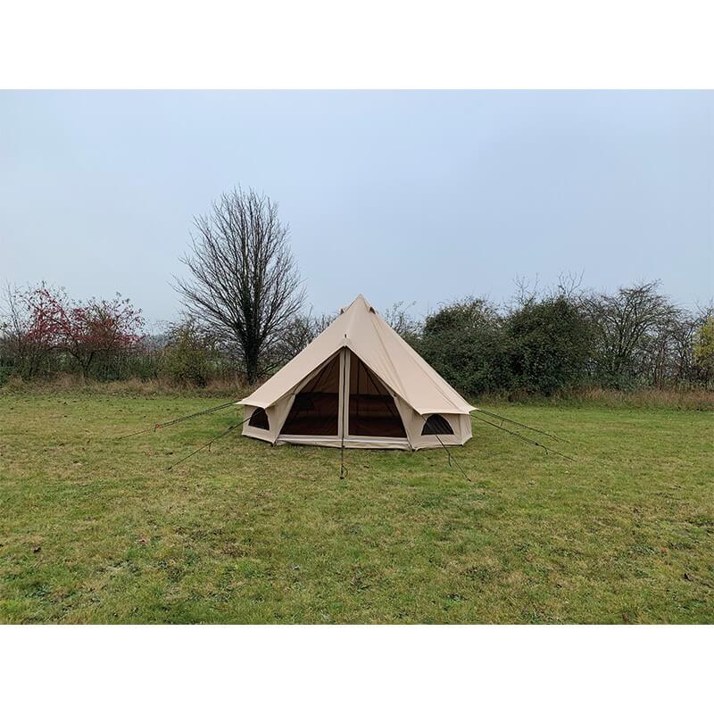 Quest Leisure Signature 4M Classic Bell Tent front view with entrance open, pitched on green grass with trees behind.