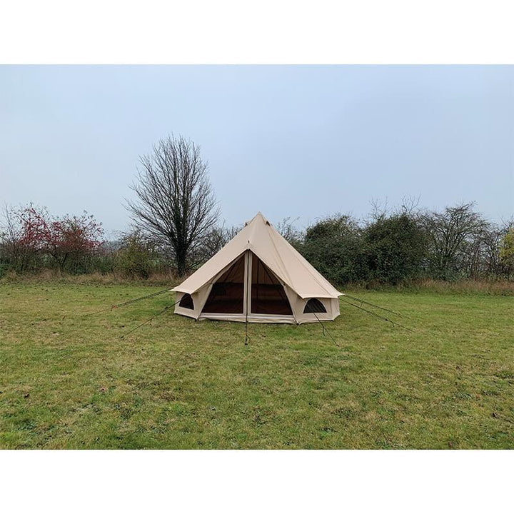 Quest Leisure Signature 4M Classic Bell Tent front view with entrance open, pitched on green grass with trees behind.