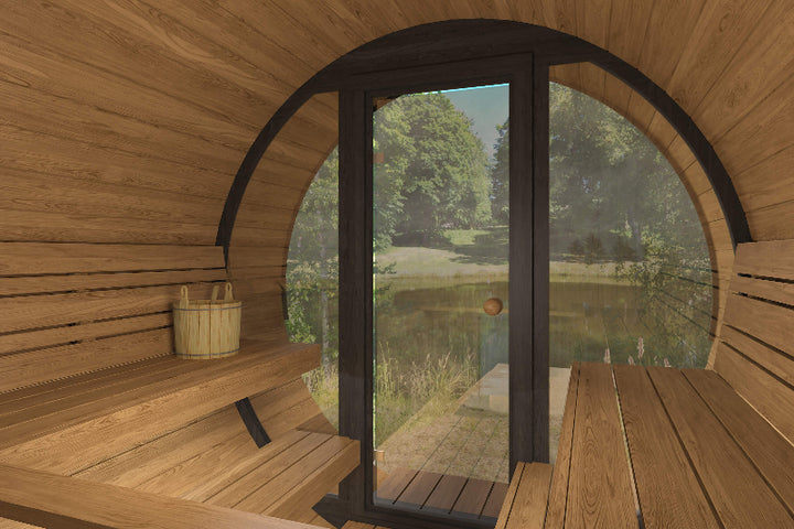 Interior angled view of InMedias Barrel Sauna 280 Deluxe facing the glass door with nature visible outside.