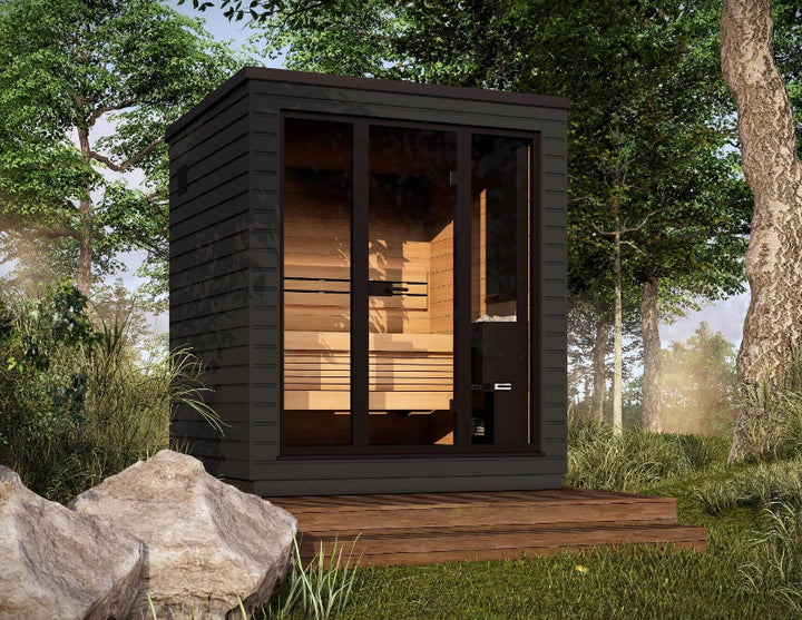 Saunum Classic Mini black-panel sauna in a natural outdoor forest location with wooden deck.