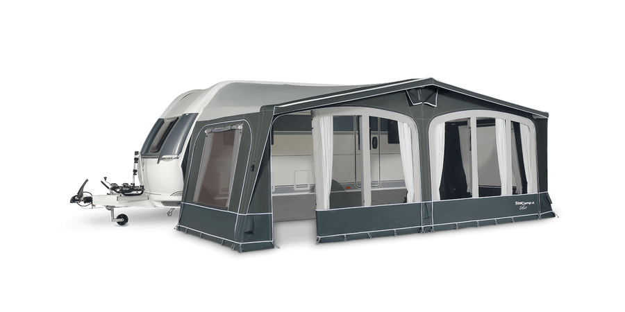 Caravan with Starcamp Valor Air inflatable awning fully set up, showing clear window panels and curtains, attached to the side of a white touring caravan, with a transparent background.