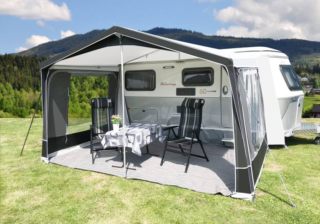 Wide shot of Walker Touring-Plus awning with open front, revealing dining setup beside Eriba caravan.
