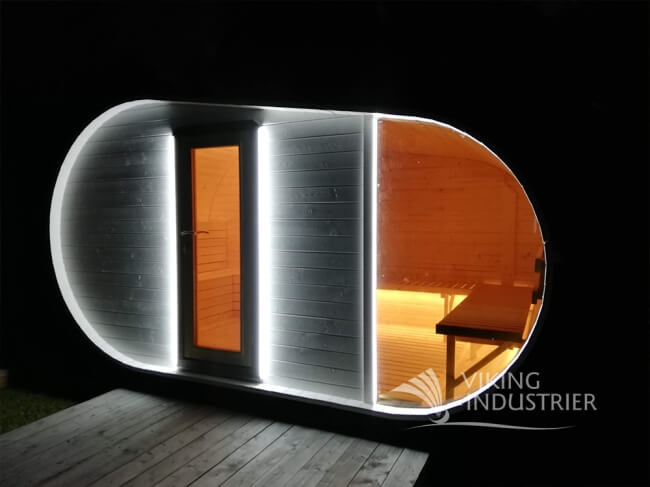 Viking Industrier Delight Outdoor Sauna 2.4 x 4.3m with LED lighting at night on a black background.