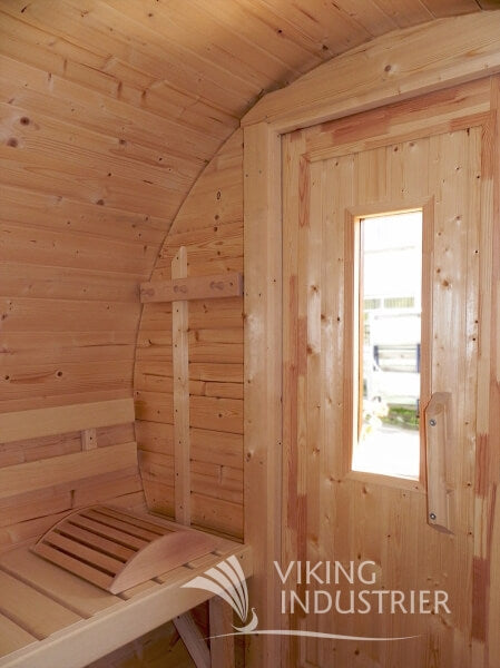 Interior of Viking Industrier Barrel Sauna 2.2 x 2.5m showing wooden bench seating and door with vertical glass window.