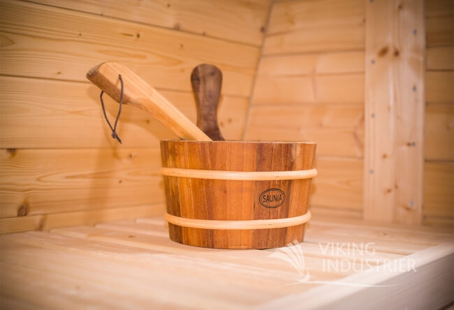 Close-up of wooden sauna bucket and ladle on the bench inside Viking Industrier Barrel Sauna 2.2 x 2.5m.