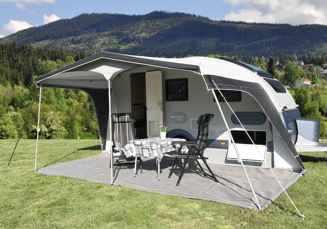 Open-sided Walker awning on the Adria Action 391, revealing setup with dining chairs and a table on a grey outdoor rug.