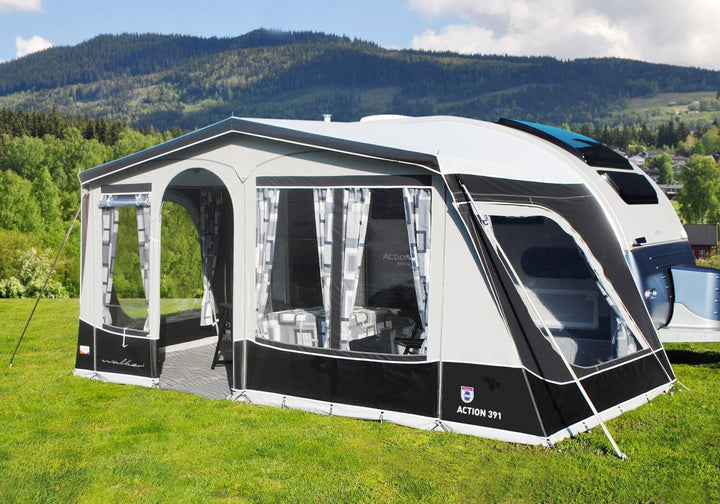 Side view of the Walker awning fully extended on the Adria Action 391, set in a bright, scenic mountain location.