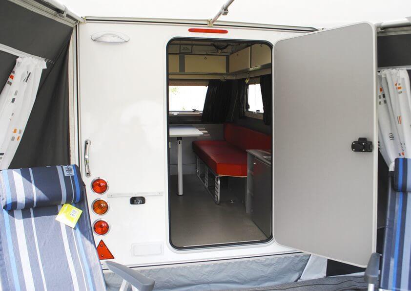 Rear access into caravan through Walker Kip Shelter Awning showing open door and visible interior seating.