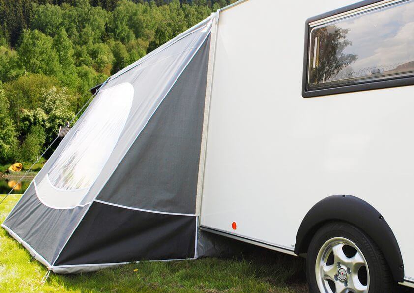 Side view of Walker Kip Shelter Awning fitted to a white caravan with black fabric and large side window.