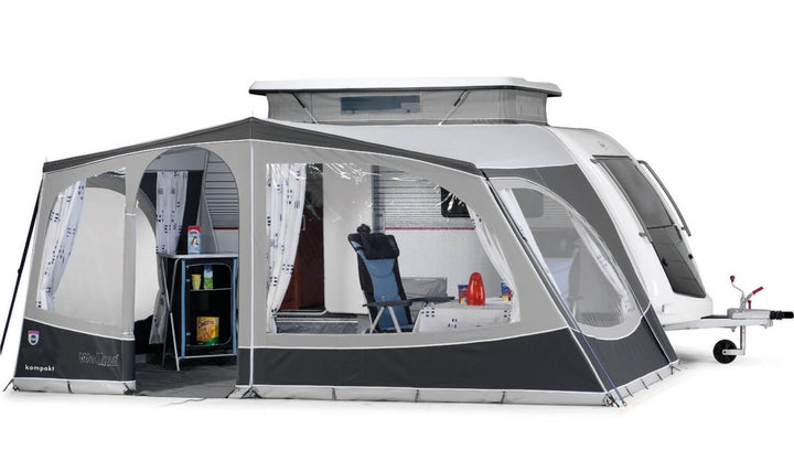Walker Kip Kompakt awning fully enclosed with curtains, side windows, and visible interior setup including chairs and table, with white background.