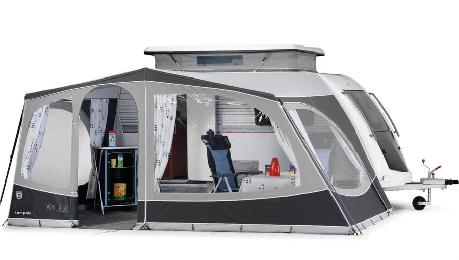 Walker Kip Kompakt awning fully enclosed with curtains, side windows, and visible interior setup including chairs and table, with white background.