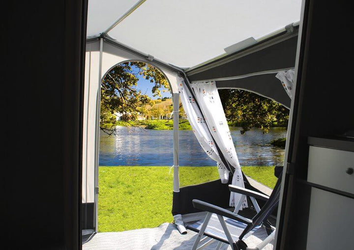 Interior view from inside the Walker Kip Shelter Awning looking out at a lakeside scene through open panels.