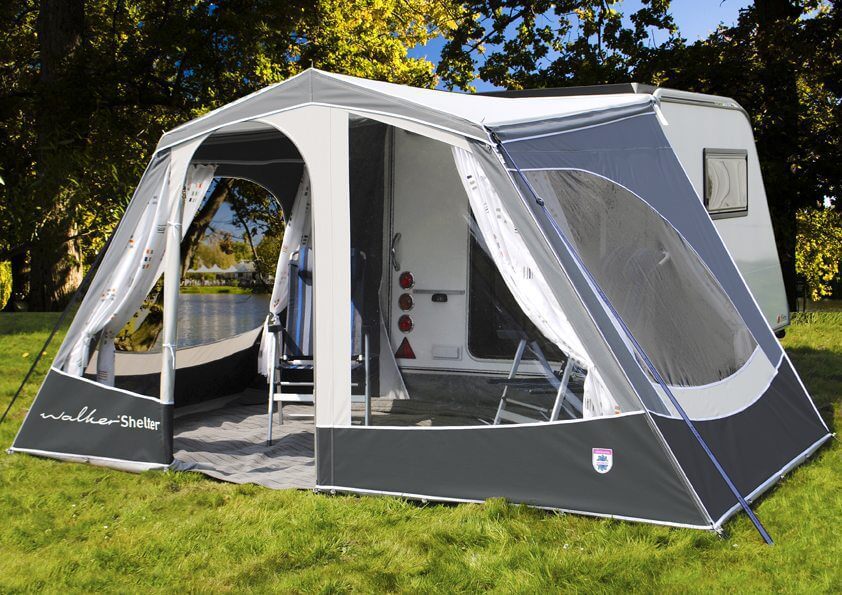 Angled view of Walker Kip Shelter Awning by a river, showing open sides and awning mounted to caravan rear.