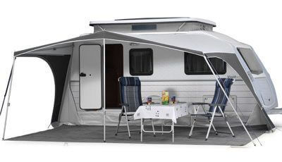 Walker Kip Vision awning fully enclosed with clear windows and patterned curtains, attached to a Kip Vision caravan with extended roof, on white background.